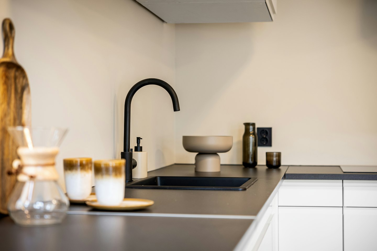 Modern kitchen counter with coffee accessories and decorative items.