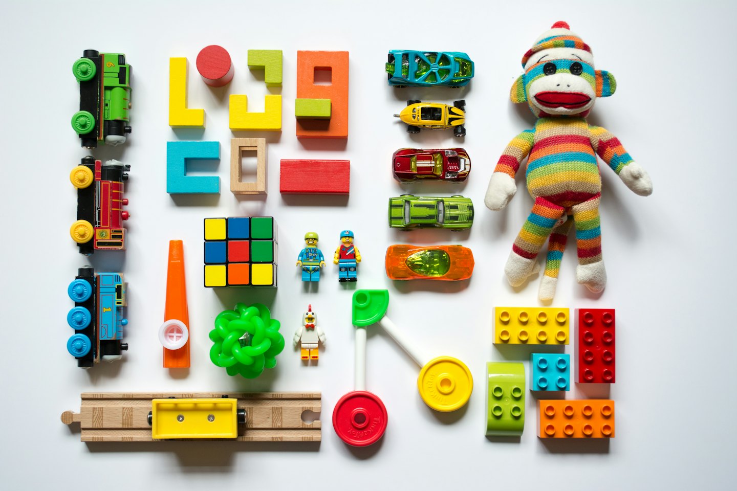 Colorful children's toys arranged on a white background.